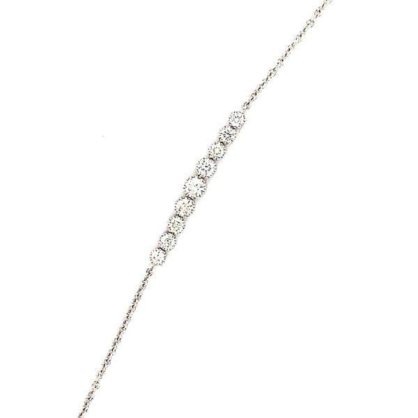 This gorgeous 14 kt white gold diamond bracelet features 9 round diamonds in a milgrained bezel setting in the center of the 